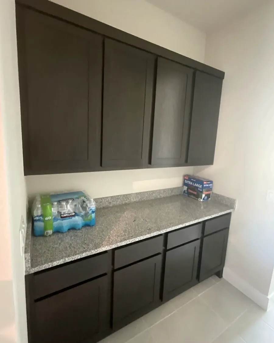Butler pantry with dark shaker cabinets and a speckled granite counter