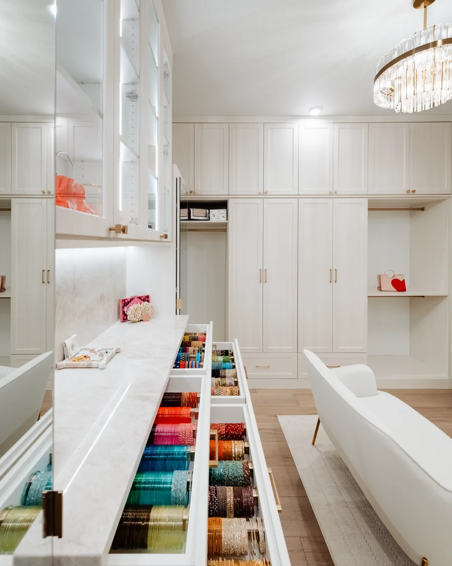 Walk-in closet island with open drawers and full-height storage on both walls