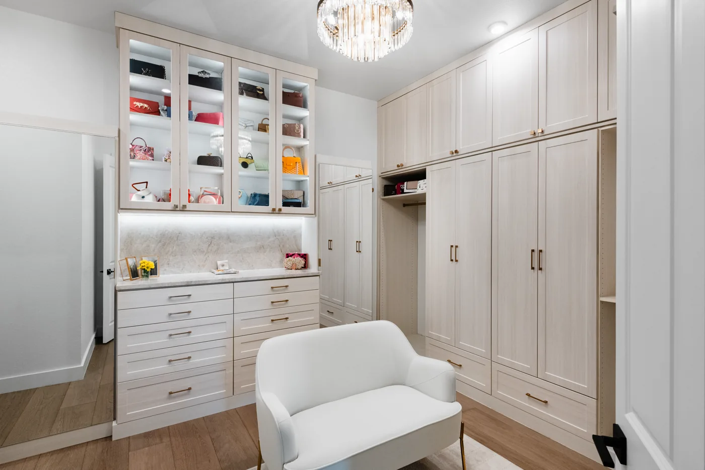 Custom walk-in closet with island and lit shelving in an Austin home