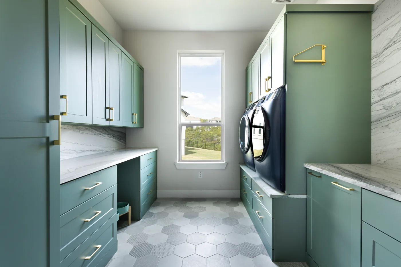 Custom laundry room cabinets with folding counter and hanging rod near Austin