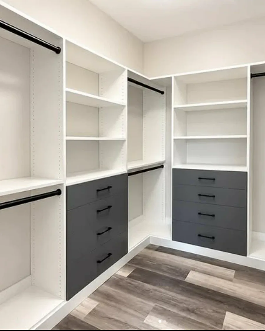 Custom closet with white shelving, hanging at two heights and charcoal drawer banks