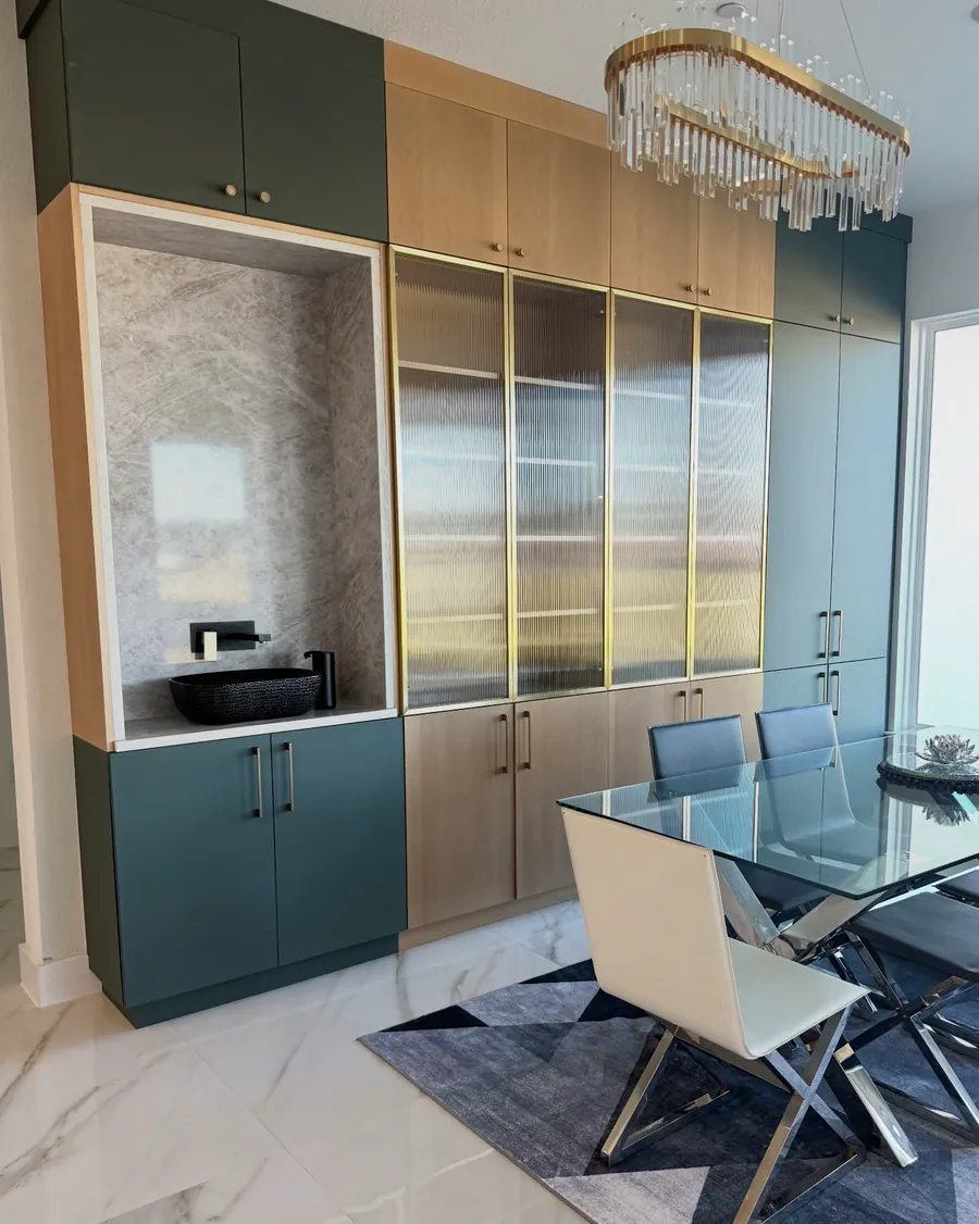 Green and light wood built-in cabinetry with reeded glass doors and a vessel sink