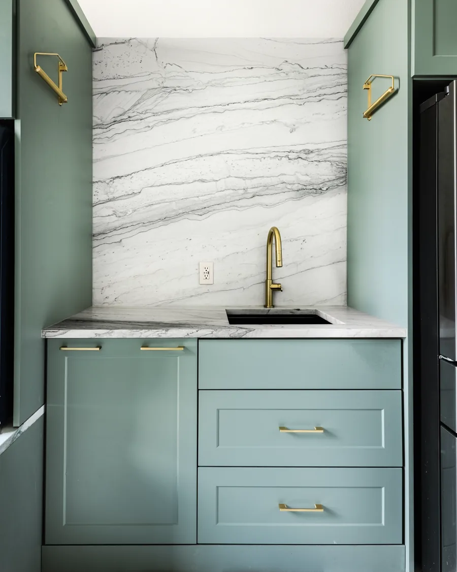 Laundry room with green cabinetry, a folding counter and a window between runs