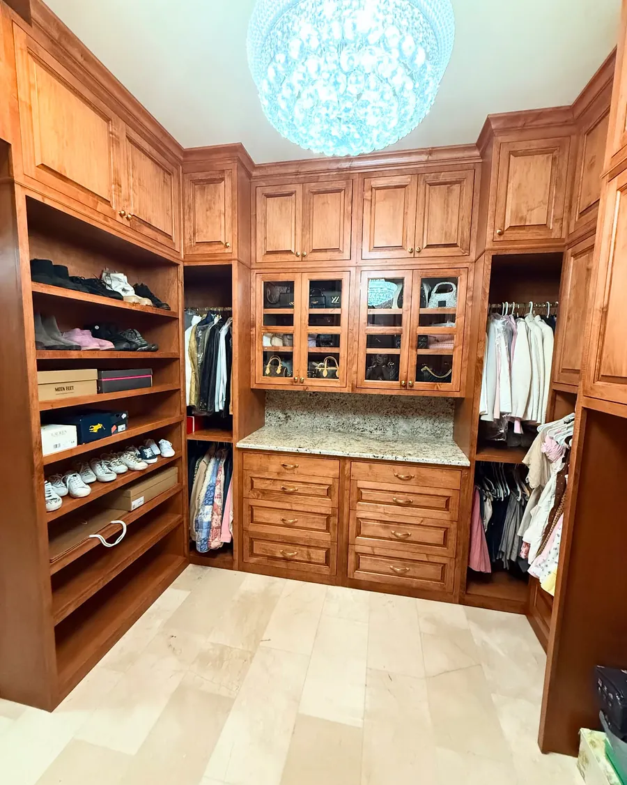 Inset maple closet with glass-front cabinets, a granite counter and blind corner storage