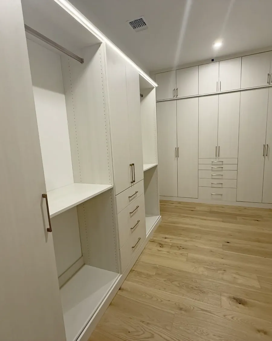 White walk-in closet with full-height wardrobes, drawer banks and adjustable shelving