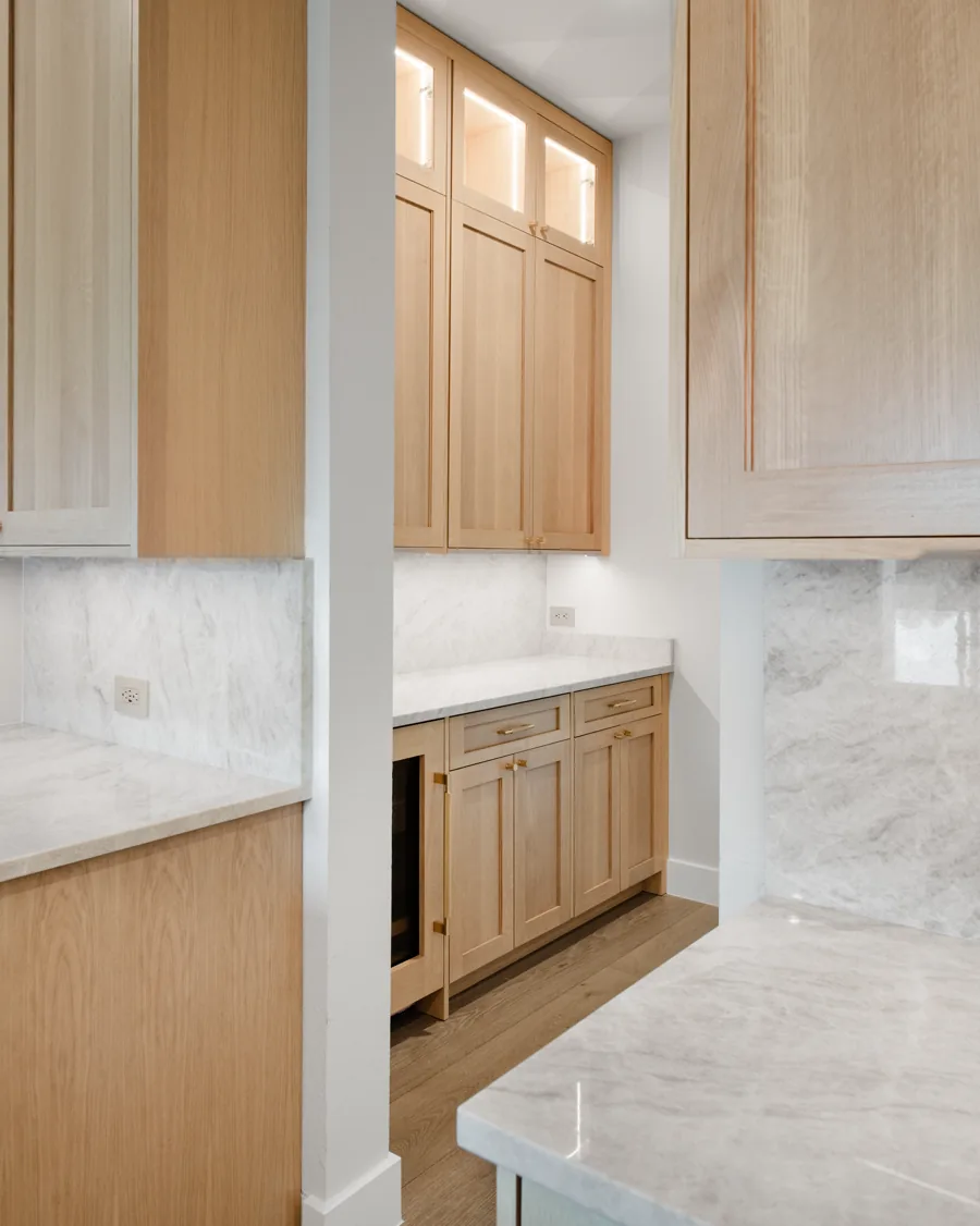 White oak kitchen cabinetry with deep drawer banks below a marble counter