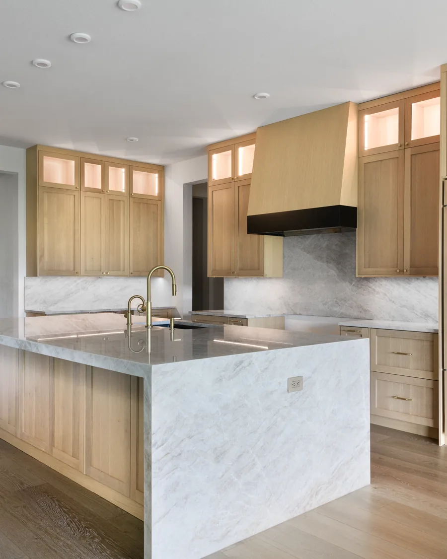 Remodeled kitchen with white oak cabinetry and a marble island