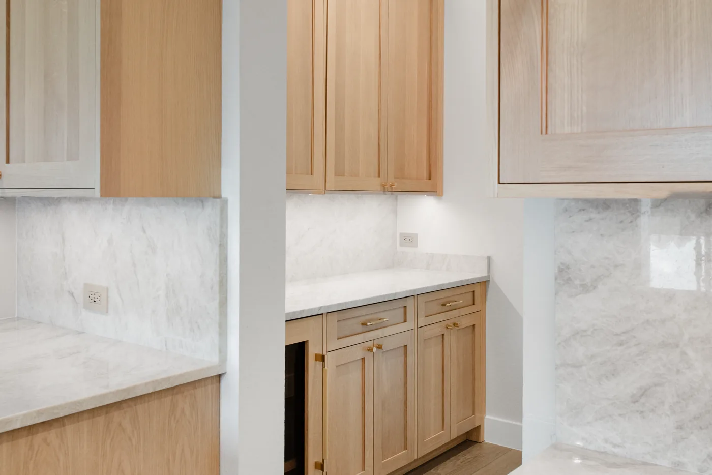 White oak kitchen cabinetry with deep drawer banks below a marble counter