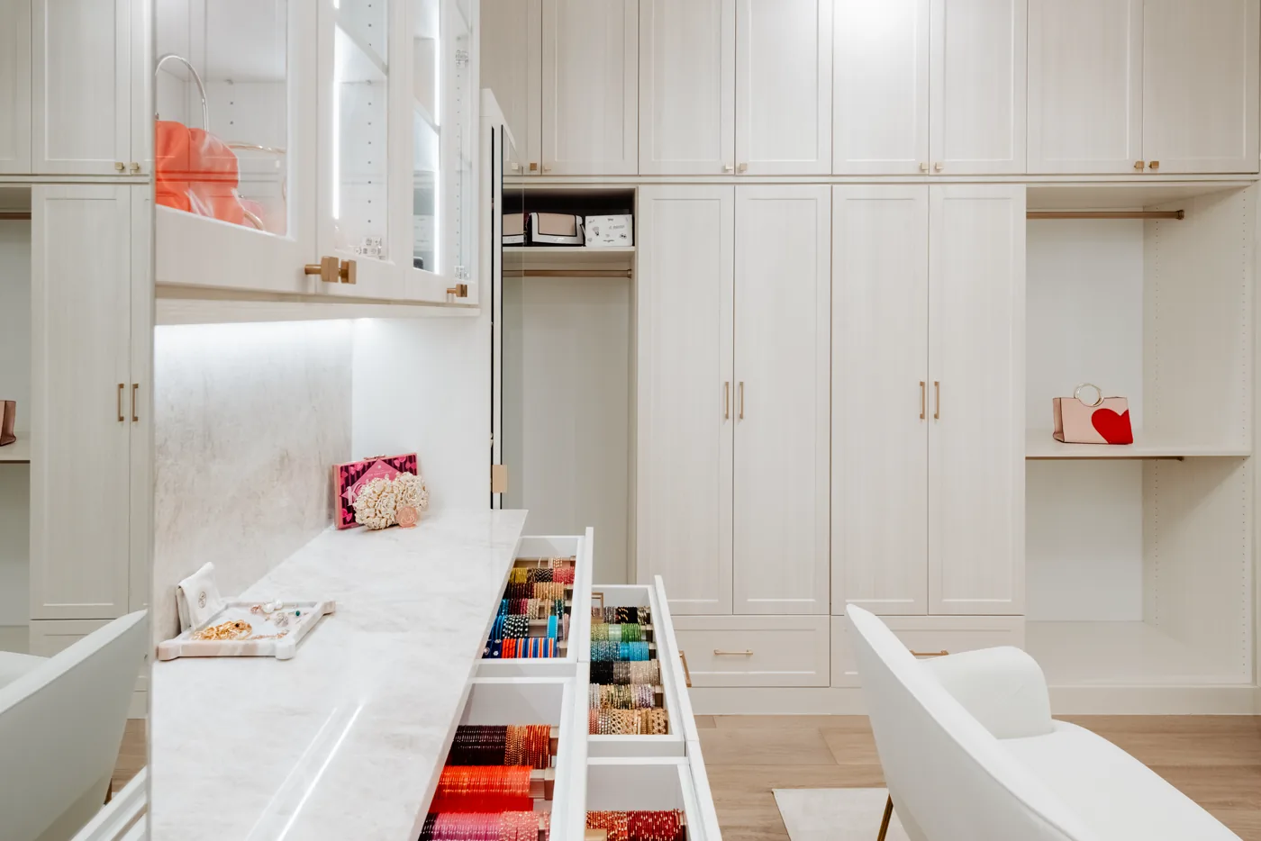Walk-in closet island with open drawers and full-height storage on both walls