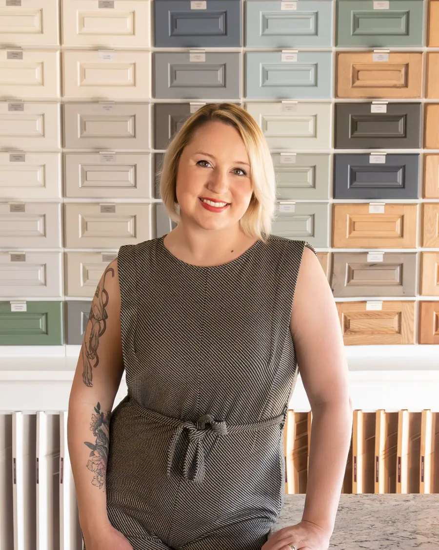 Savannah Hargett, owner of Monet Interior Closets and Cabinets, at a wall of cabinet door styles and finishes